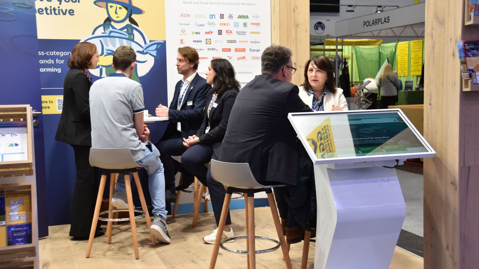 Stakeholders in conversation at the GLOBALG.A.P. and GGN label booth at Fish International 2024 in Bremen, Germany.