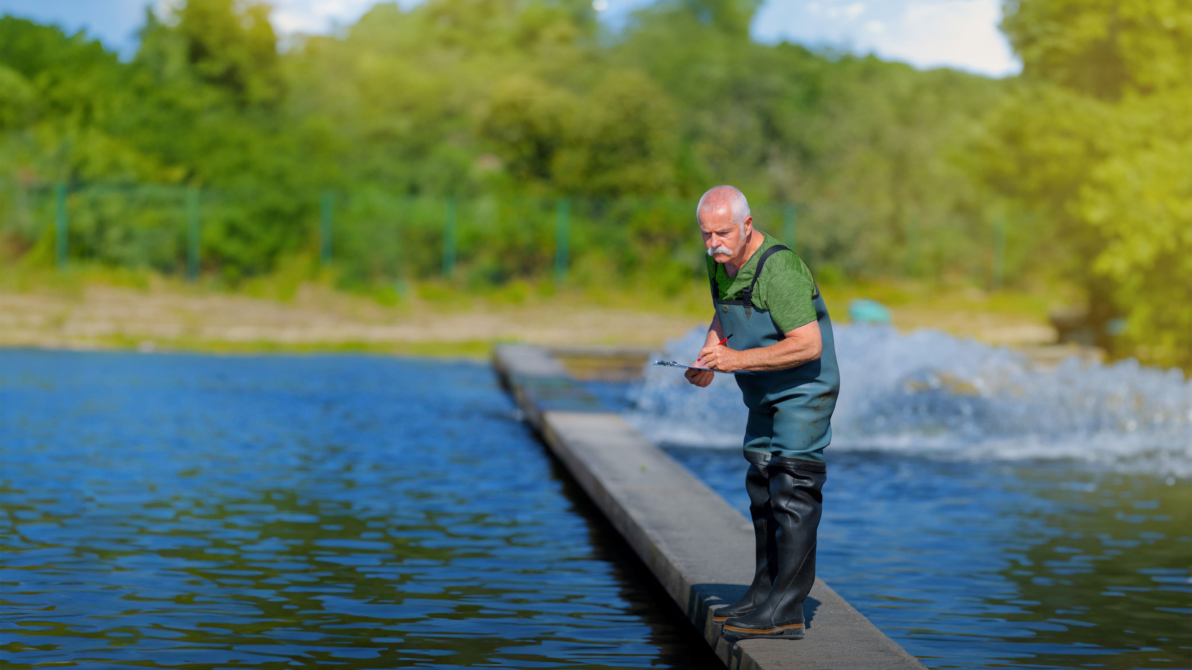 A farm auditor checks data on the premises of an aquaculture site to determine whether the processes are in line with GLOBALG.A.P. standards for safe and responsible agriculture.