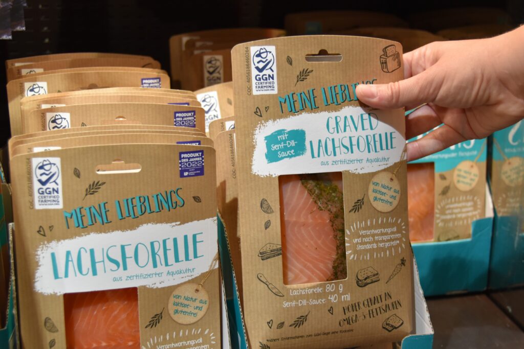 Photo of a consumer selecting packaged smoked salmon with the GGN label.